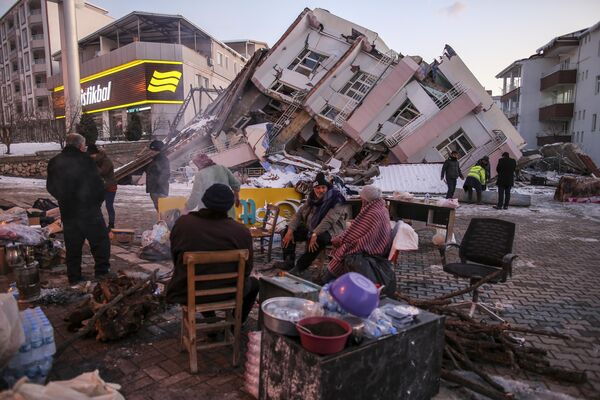 Люди возле рухнувших зданий в Голбаси, Турция. - Sputnik Азербайджан