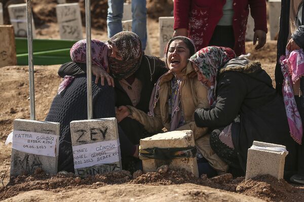 Люди на кладбище в Адиямане хоронят своих близких, жертв землетрясения в Турции. - Sputnik Азербайджан