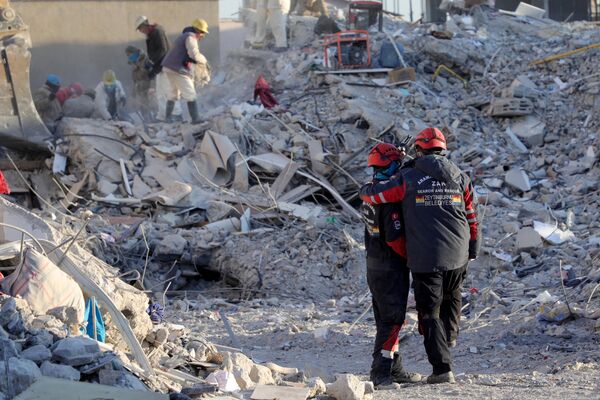 Члены поисково-спасательной группы среди обломков разрушенных зданий в Нурдаги, Турция. - Sputnik Азербайджан