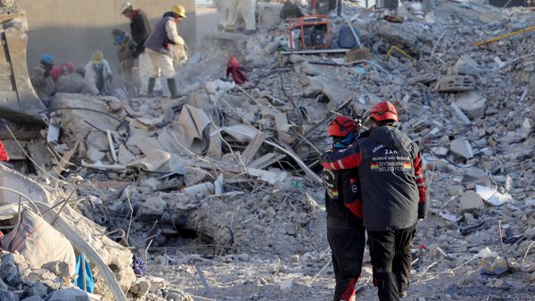 Члены поисково-спасательной группы среди обломков разрушенных зданий в Нурдаги, Турция - Sputnik Азербайджан