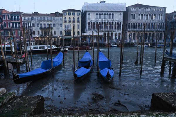 Гондолы, пришвартованные вдоль канала с низким уровнем воды во время отлива в Венеции, Италия. - Sputnik Азербайджан