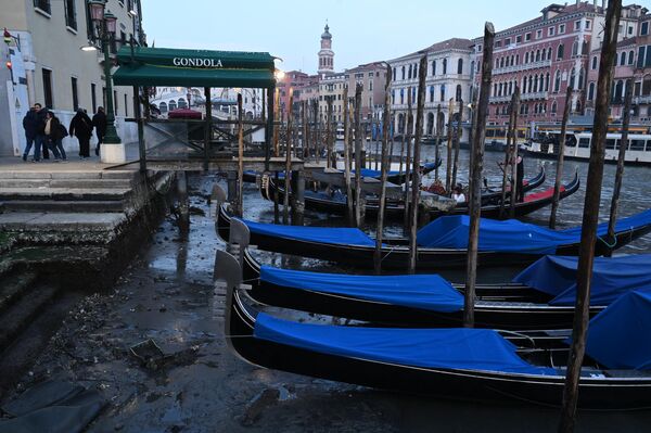 İtaliyanın Venesiya şəhərində suyun çəkilməsi zamanı kanal boyunca bağlanmış qayıqlar. - Sputnik Azərbaycan