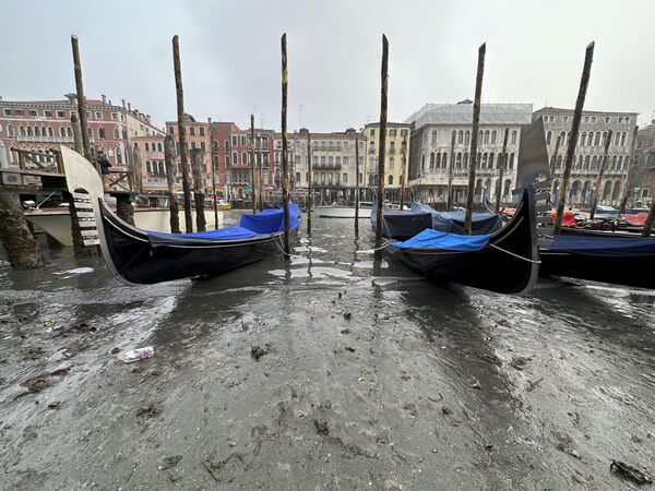 Гондолы, пришвартованные вдоль канала с низким уровнем воды во время отлива в Венеции, Италия. - Sputnik Азербайджан