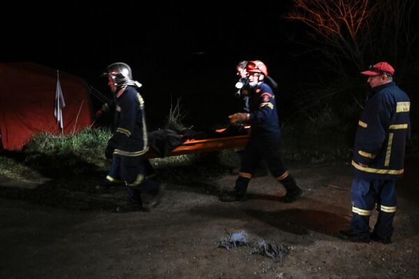 Спасатели несут тело, извлеченное из-под обломков после крушения поезда. - Sputnik Азербайджан