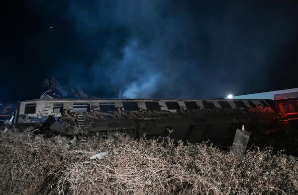 Сошедшие с рельсов вагоны лежат на боку после крушения поезда недалеко от Ларисы. - Sputnik Азербайджан