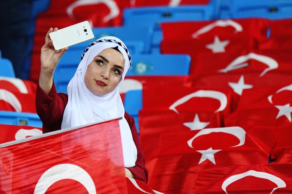 Болельщица сборной Турции фотографируется на зрительской трибуне перед началом матча. - Sputnik Азербайджан
