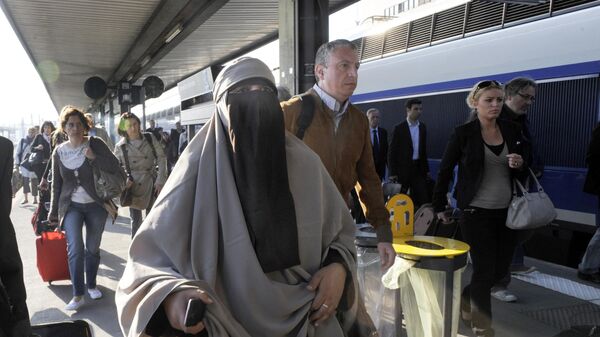 Молодая женщина в хиджабе идет по платформе Лионского вокзала в Париже - Sputnik Азербайджан