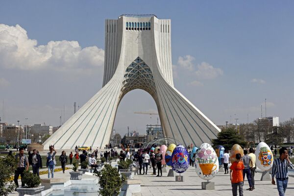 Люди собираются вокруг разноцветных яиц на площади Азади в Тегеране во время празднования Новруза. - Sputnik Азербайджан