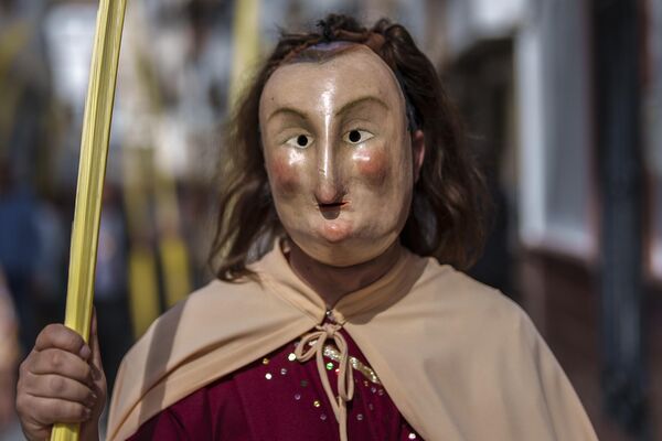 Мужчина, одетый в костюм апостола, во время шествия в Вербное воскресенье в Испании. - Sputnik Азербайджан
