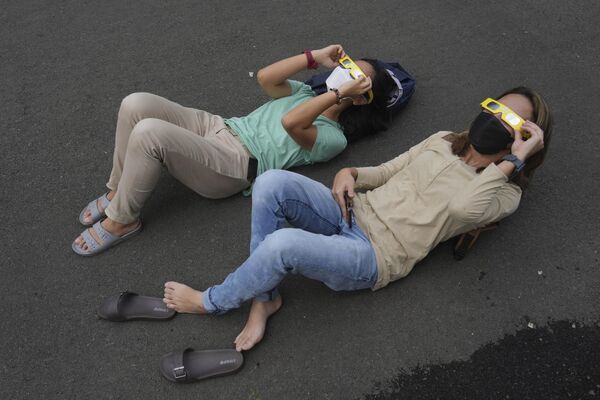 Люди наблюдают за солнечным затмением 2023 года в Индонезии. - Sputnik Азербайджан