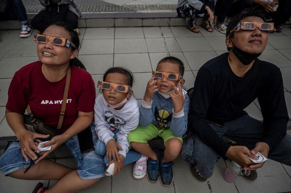 Люди наблюдают за солнечным затмением 2023 года в Индонезии. - Sputnik Азербайджан