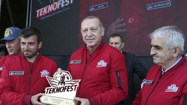 Президент Турции Реджеп Тайип Эрдоган (в центре) получает сувенир от своего зятя Сельчука Байрактара (слева) во время Teknofest, фото из архива - Sputnik Азербайджан