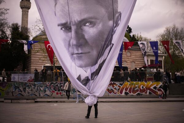 Рабочий убирает гигантский транспарант с изображением Мустафы Кемаля Ататюрка. - Sputnik Азербайджан