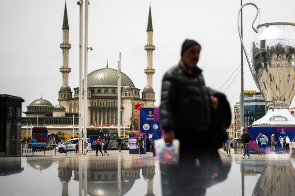 İnsanlar İstanbulun Taksim meydanında Çempionlar Liqası Kubokunun maketinin yanından keçirlər. - Sputnik Azərbaycan