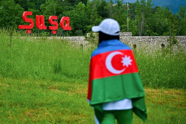 Девушка с флагом Азербайджана напротив крепостных стен в Шуше.  - Sputnik Азербайджан