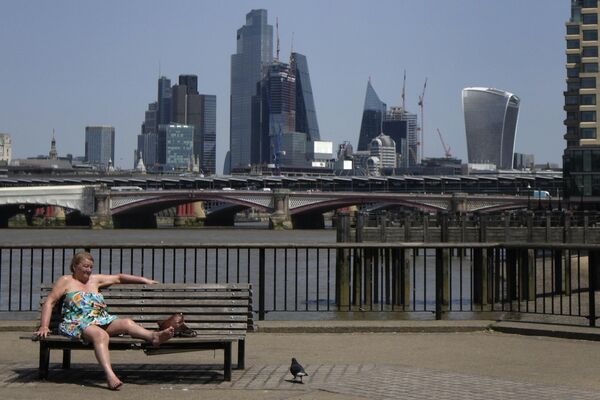 Женщина загорает у реки Темзы в Лондоне. - Sputnik Азербайджан