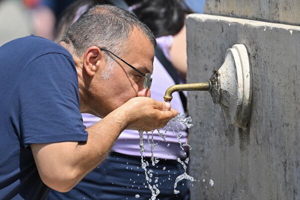 Мужчина пьет воду из фонтана в Ватикане. - Sputnik Азербайджан