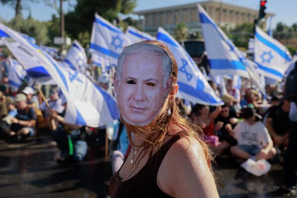 Демонстрант в маске с изображением премьер-министра Израиля Биньямина Нетаньяху на акции протеста в Иерусалиме. - Sputnik Азербайджан