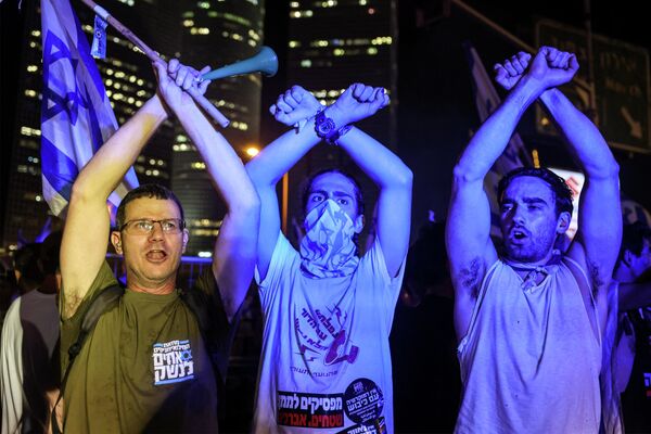 Протестующие стоят, скрестив руки в воздухе, во время акции протеста против плана израильского правительства по судебной реформе в Тель-Авиве. - Sputnik Азербайджан