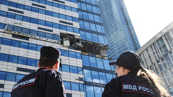 Сотрудники полиции у поврежденного здания делового центра Москва-сити в результате атаки украинских беспилотников - Sputnik Азербайджан