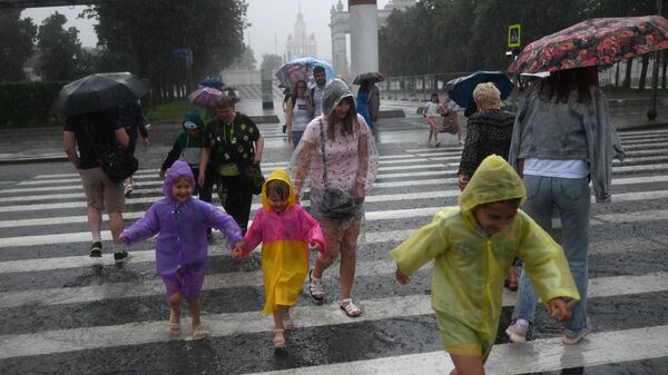 Люди переходят улицу по пешеходному переходу во время дождя в Москве - Sputnik Азербайджан