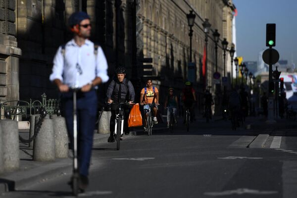 Люди передвигаются по улицам Парижа на велосипедах и самокатах. - Sputnik Азербайджан