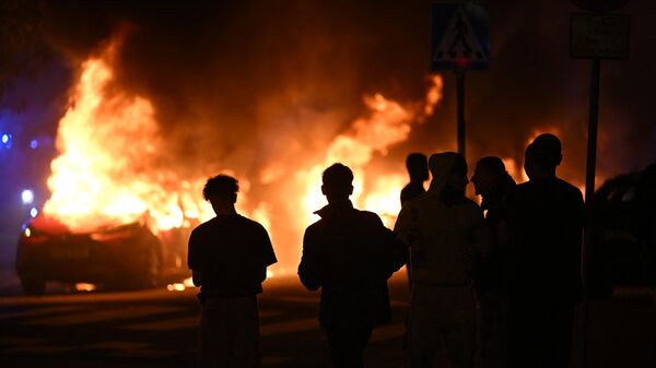 Люди смотрят, как горят машины, после беспорядков в Швеции - Sputnik Азербайджан