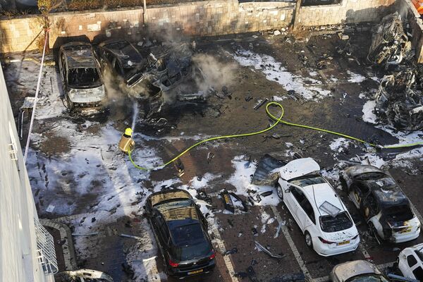 Израильские пожарные тушат огонь после того, как ракета, выпущенная из сектора Газа, попала на парковку в Ашкелоне. - Sputnik Азербайджан