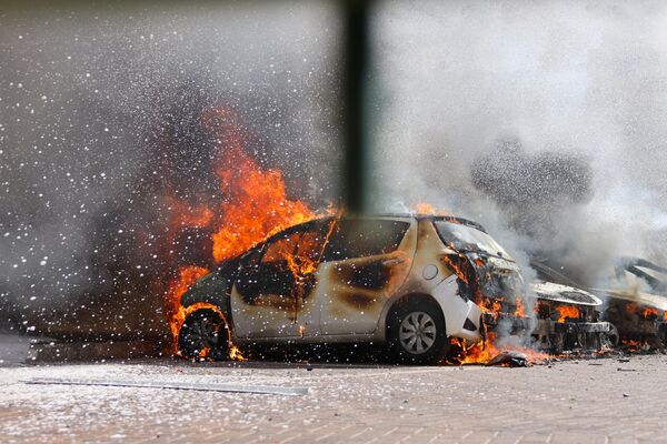 Машины горят после ракетного обстрела из сектора Газа в Ашкелоне, на юге Израиля. - Sputnik Азербайджан