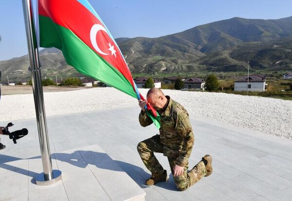 Далее Президент Ильхам Алиев поднял Государственный флаг Азербайджана в городе Ходжалы. - Sputnik Азербайджан