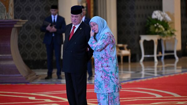 Королева Малайзии Тунку Азиза Амина Маймуна Искандария (справа) обнимает своего брата султана Ибрагима Искандара  - Sputnik Азербайджан