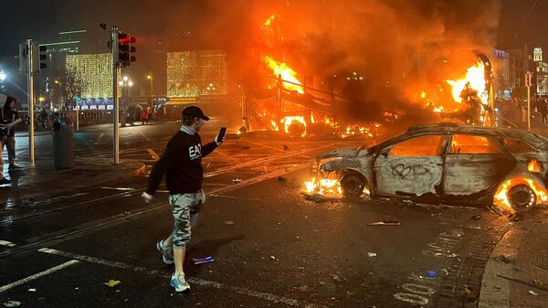 Сожженный во время беспорядков автомобиль в Дублине - Sputnik Азербайджан