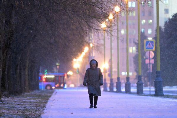 Женщина идет во время снегопада на одной из улиц в Москве. - Sputnik Азербайджан
