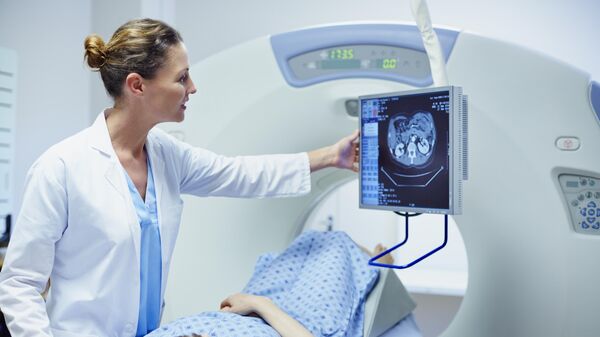 Врач показывает пациенту компьютерную томографию в смотровом кабинете больницы - Sputnik Азербайджан
