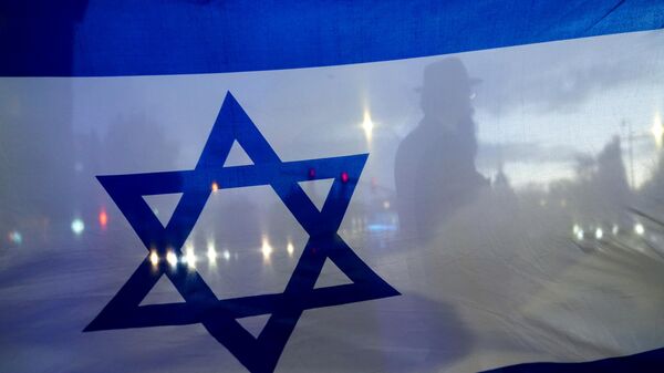 Мужчина на фоне флага Израиля, фото из архива - Sputnik Азербайджан
