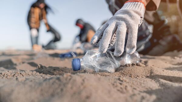 Волонтер собирает мусор на пляже - Sputnik Азербайджан