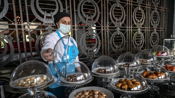 Работник показывает печенье в кондитерской курортного отеля в Анталье - Sputnik Азербайджан
