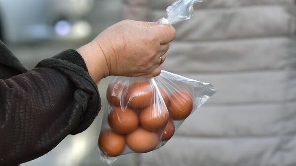 Женщина покупает яйца на продовольственной ярмарке в Симферополе - Sputnik Азербайджан