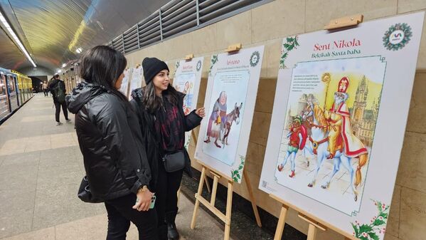 Пассажиры смотрят новогоднюю выставку на станции метро &quot;Ичеришехер&quot;. - Sputnik Азербайджан