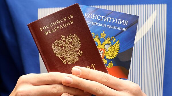 Молодой человек держит паспорт РФ - Sputnik Азербайджан