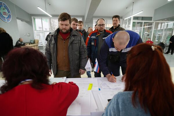 Люди регистрируются перед началом голосования на выборах президента России в Мариуполе - Sputnik Азербайджан