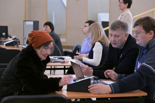 Члены участковой избирательной комиссии регистрируют женщину на выборах президента России в Москве - Sputnik Азербайджан