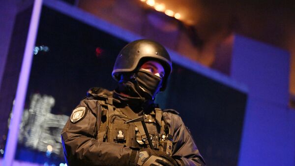 Сотрудник полиции у концертного зала Крокус Сити Холл, где произошла стрельба - Sputnik Азербайджан