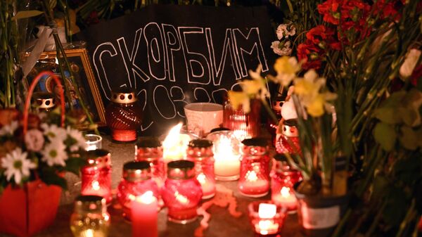 Цветы и свечи у стихийного мемориала у здания концертного зала Крокус Сити Холл - Sputnik Азербайджан