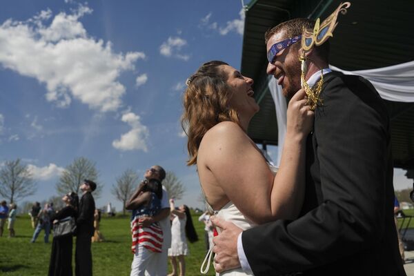 Жених и невеста танцуют и во время полного солнечного затмения, штат Огайо, США. - Sputnik Азербайджан