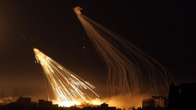 Вспышки и дым видны во время израильской военной операции 