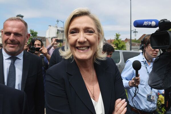 Marin Le Pen parlament seçkilərinin ilk turunda səs verdikdən sonra seçki məntəqəsini tərk edərkən media qarşısında gülümsəyərək şəkil çəkdirir. - Sputnik Azərbaycan