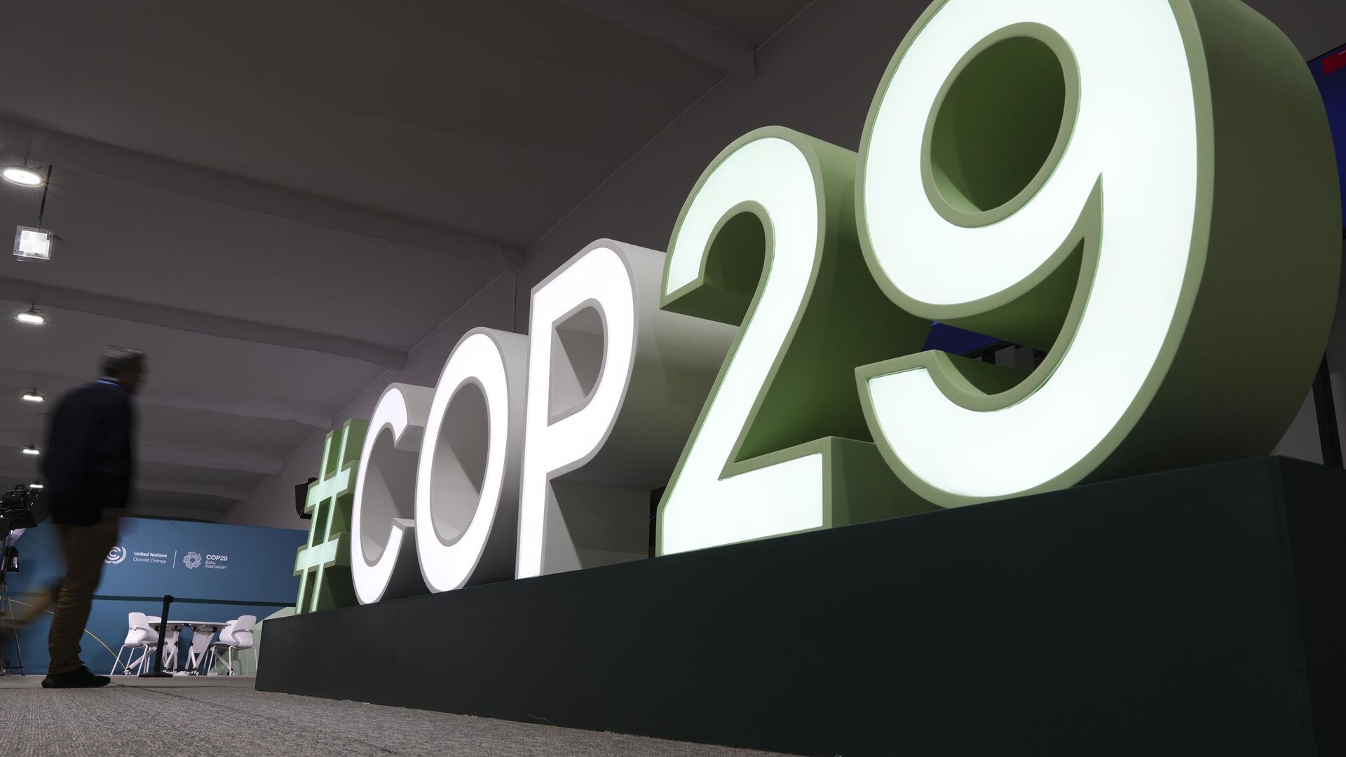 Участник идет возле знака климатического саммита COP29 в Баку - Sputnik Азербайджан, 1920, 21.11.2024