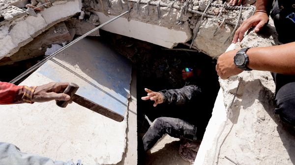 Человек передает молоток мужчине во время поиска жертв под завалами здания после землетрясения в Ла-Гуайре, Венесуэла - Sputnik Азербайджан