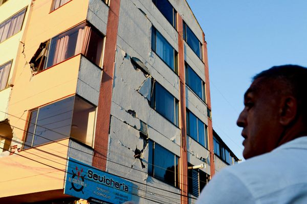 Мужчина стоит перед зданием, поврежденным в результате землетрясения, в Манисалесе - Sputnik Азербайджан